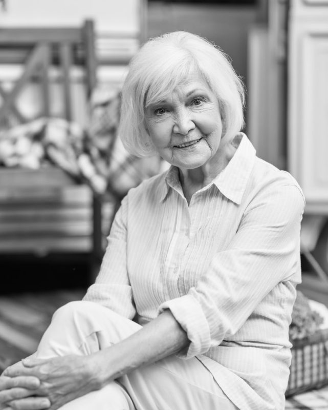smiling-gray-haired-lady-resting-near-her-motorhomDNRW58M